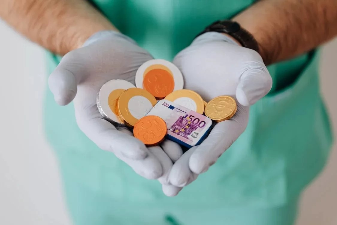 Doctor holding coins in his hands